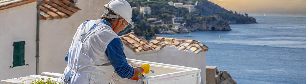 Hvad koster en håndværker i Frankrig? Billede af en håndværker i Villefranche som arbejder på et hus ved havet