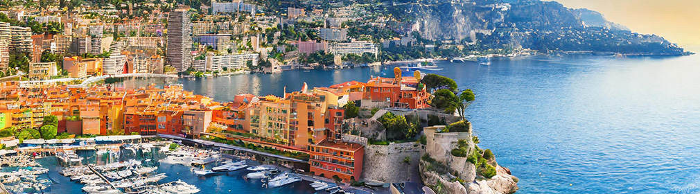 Panorama billede af Monaco havn med havet og smukke gulige bygninger